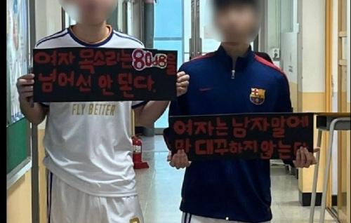 경기 안양시의 한 고등학교에서 남자 고교생들이 '여자 목소리는 80㏈을 넘어선 안 된다' '여자는 남자 말에 말대꾸하지 않는다'는 문구를 적은 피켓을 들고 있다. 16일부터 사회관계망서비스(SNS)를 통해 확산되며 