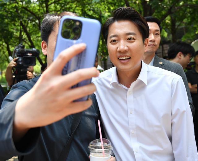 이준석 개혁신당 대선 후보가 30일 서울 마포구 경의선 숲길 공원에서 한 시민과 사진 촬영을 하고 있다. 공동취재사진 뉴스1