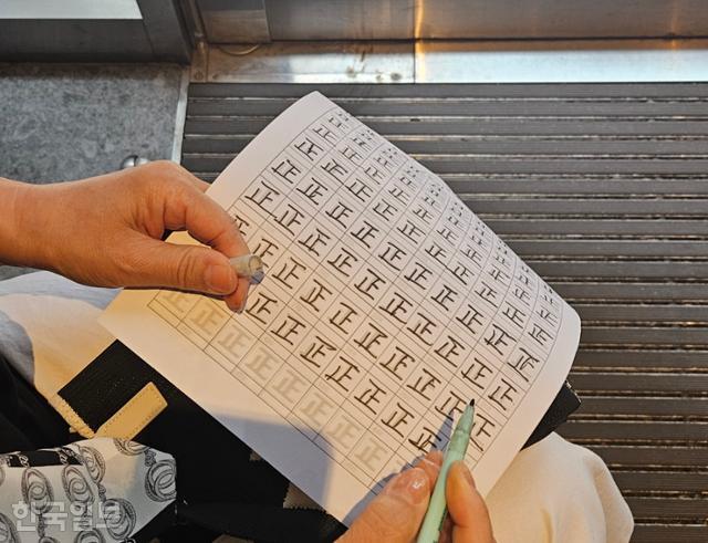 29일 서울 중구의 한 투표소 앞 카페에서 60대 여성이 투표장을 찾은 시민들의 수를 일일이 세어 흰 종이에 '바를 정'(正) 한자로 쓰고 있다. 해당 계수는 부정선거인지 감시한다는 취지에서 진행됐다. 이유진 기자