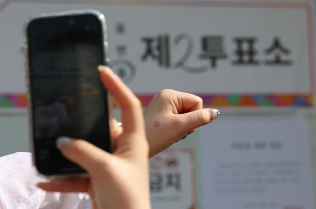 제21대 대통령 선거일인 3일 경기 수원시 권선구 여기산게이트볼장에 마련된 서둔동제2투표소에서 한 유권자가 투표를 마치고 인증샷을 남기고 있다. 뉴스1