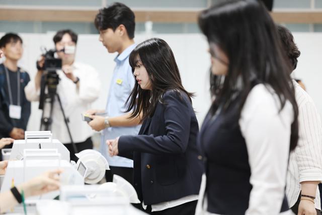 제21대 대통령 선거 사전투표 첫날인 지난달 29일 오후 광주 서구 화정2동 사전투표소에서 고교 3학년 학생들이 생애 첫 투표를 위해 투표용지를 건네받고 있다. 연합뉴스