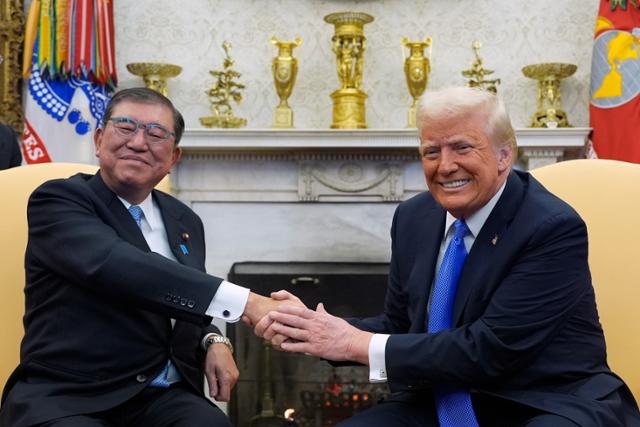지난 2월 7일(현지시간) 이시바 시게루(왼쪽) 일본 총리와 도널드 트럼프 미국 대통령이 백악관 집무실에서 회담하면서 악수하고 있다. 워싱턴=AP·뉴시스