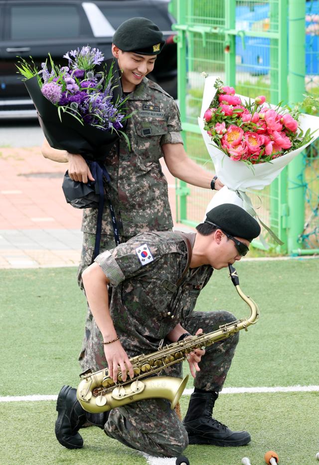 방탄소년단의 RM과 뷔가 10일 원 춘천 신북읍체육공원 축구장에서 군 복무를 마친 뒤 전역 인사를 하고 있다. 군악대에서 복무한 RM은 색소폰을 연주해 팬들을 즐겁게 했다. 뉴스1