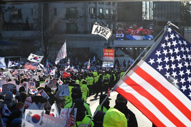윤석열 대통령에 대한 체포영장 발부 나흘째인 1월 3일 서울 용산구 한남동 대통령 관저 정문 앞에서 보수 유튜버들이 태극기와 성조기를 들고 이동하고 있다. 코리아타임스