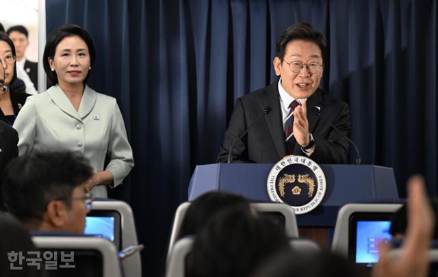 이재명 대통령이 16일 G7 정상회의 참석을 위해 캐나다 캘거리로 향하는 공군 1호기 기내에서 기자회견을 하고 있다. 이 대통령 왼쪽 뒤에서 부인 김혜경 여사가 기자회견을 지켜보고 있다. 캘거리=왕태석 선임기자