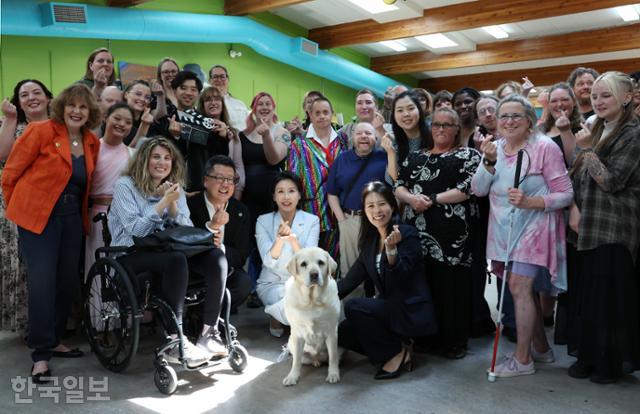 G7 정상회의에 참석하는 이재명 대통령과 함께 캐나다를 방문한 김혜경 여사가 17일 캐나다 캘거리 국립장애인예술센터를 방문해 센터활동가, 은퇴한 안내견 ‘벨라’와 함께 기념촬영을 하고 있다. 캘거리=왕태석 선임기자