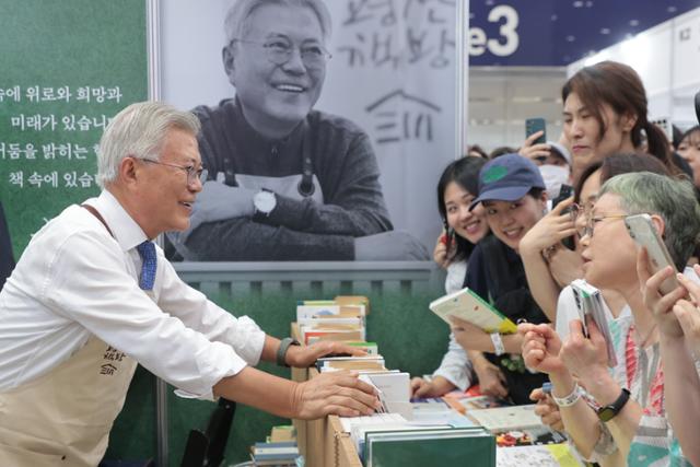 18일 서울 강남구 삼성동 코엑스에서 열린 2025 서울국제도서전을 찾은 문재인 전 대통령이 자신이 책방지기로 있는 평산책방 부스에서 관람객들과 대화하고 있다. 연합뉴스18일 서울 강남구 삼성동 코엑스에서 열린 20