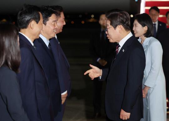 이재명 대통령이 19일 제51차 주요 7개국(G7) 정상회의 일정을 마친 뒤 성남 서울공항에 도착해 마중 나온 강훈식(왼쪽 세 번째) 비서실장과 대화하고 있다. 연합뉴스