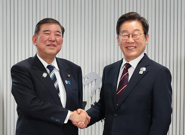 이재명 대통령이 지난 17일(현지시간) 캐나다 앨버타주 캐내내스키스 주요 7개국(G7) 정상회의장에서 열린 한일 정상회담에서 이시바 시게루 일본 총리와 악수하며 기념촬영을 하고 있다. 연합뉴스