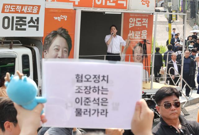 지난달 30일 이준석 당시 개혁신당 대선 후보가 서울 동작구 중앙대학교에서 유세 중인 가운데 일부 학생들이 최근 이 후보의 TV토론 여성 신체 관련 발언을 규탄하며 팻말을 들고 있다.연합뉴스