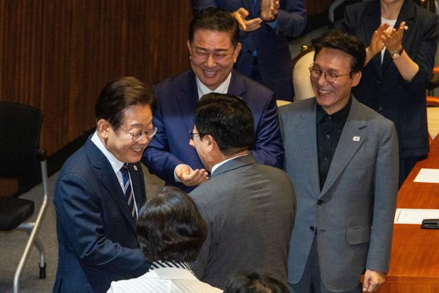 이재명 대통령이 26일 국회 본회의장에서 2025년도 제2회 추가경정예산안에 대한 정부의 시정연설을 하기 위해 본회의장으로 들어오며 더불어민주당 의원들과 인사를 나누고 있다. 2025.06.26. 고영권 기자