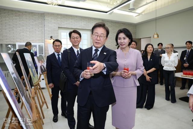 이재명 대통령과 부인 김혜경 여사가 30일 서울 용산구 대통령실 파인그라스에서 열린 문화예술계 수상자 간담회 '문화강국의 꿈, 세계로 나아가는 대한민국' 행사에서 K컬처 주역들의 활약상이 담긴 사진을 보고 있다. 왕