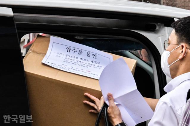 3일 서울 중구 전 삼부토건 사무실에서 나온 김건희 특검 관계자들이 압수물을 차에 싣고 있다. 압수물 봉인 관련 안내문에 '김건희와 명태균·건진법사 관련 국정농단 및 불법 개입 사건 등 진상 규명을 위한 특별검사'라