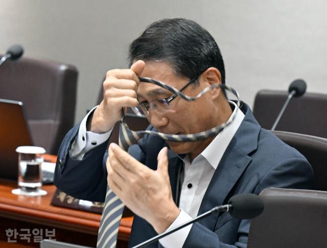 8일 대통령실에서 열린 국무회의에 참석한 유재성 경찰청 차장이 복장이 노타이 차림이라는 사실을 뒤늦게 알고 넥타이를 풀고 있다. 왕태석 선임기자