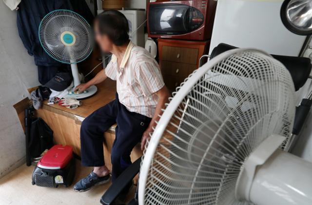 서울 시내 한 아파트 경비실에서 경비원이 선풍기를 이용해 더위를 식히고 있다. 뉴시스