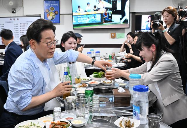 이재명 대통령이 11일 서울 종로구의 한 식당에서 가진 외식 행사에서 직원들에게 술을 따라주고 있다. 왕태석 선임기자