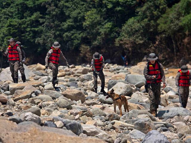 수해 복구 대민지원에 나선 육군 39사단 장병들이 지난달 24일 경남 산청군에서 물이 없는 상태에서도 구명조끼를 착용한 가운데 폭우 실종자를 수색하고 있다. 육군 제공