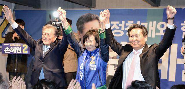 서울 마포을에 출마하는 손혜원(가운데) 더불어민주당 홍보위원장의 선거사무소 개소식이 열린 2016년 3월 24일 문재인(왼쪽) 전 대표, 정청래 의원이 손 후보와 함께 손을 들어 인사하고 있다. 연합뉴스