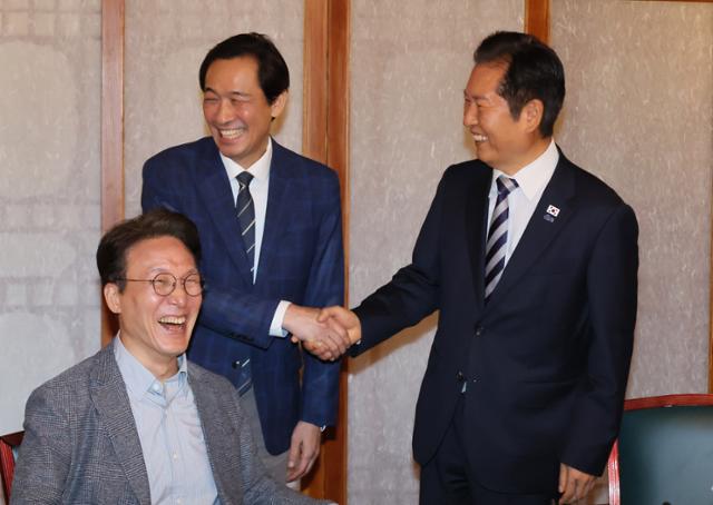 정청래(오른쪽) 더불어민주당 대표와 우상호 정무수석이 12일 서울 종로구 총리공관에서 열린 고위당정협의회에 참석해 악수하고 있다. 연합뉴스