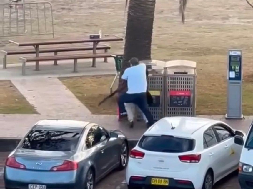 흰 옷을 입은 남성이 14일 본다이 비치에서 총격범을 맨몸으로 제압하고 있다. X 캡처