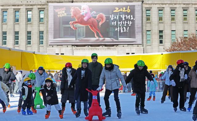 새해 첫 날인 1일 서울 중구 서울광장 스케이트장을 찾은 시민들이 병오년(丙午年) 붉은 말의 역동적인 이미지를 담은 서울도서관 외벽을 배경으로 스케이트를 즐기고 있다.뉴스1