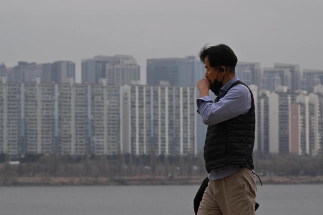 수도권 미세먼지 농도가 '나쁨'을 기록한 지난해 3월 12일 서울 영등포구 여의도 한강공원에서 마스크를 쓴 시민이 재채기를 하며 이동하고 있다.박시몬 기자