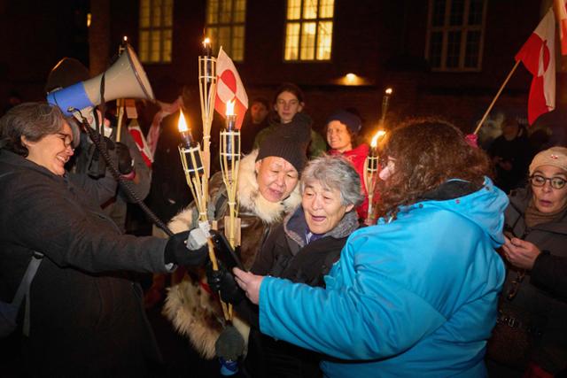 그린란드 국기와 횃불을 든 시위대가 14일 덴마크 코펜하겐의 미국 대사관 앞에서 "그린란드는 그린란드 주민을 위해 존재한다"는 구호를 외치고 있다.미국 정부는 최근 그린란드의 전략적 위치와 풍부한 희토류 자원 확보