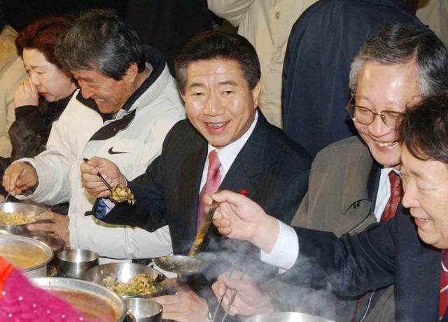 노무현(가운데) 전 대통령이 새천년민주당 대통령 후보 시절이었던 2002년 11월 27일 대구 칠성시장에서 거리 유세를 마친 뒤 점심으로 보리밥을 먹고 있다. 한국일보 자료사진