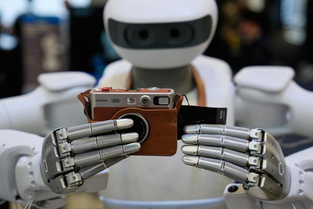 싱가포르 기업 샤르파의 휴머노이드 로봇 '노스'가 7일 미국 라스베이거스에서 열린 CES에서 미세한 손가락 관절로 카메라를 조작하고 있다.라스베이거스=AP 연합뉴스