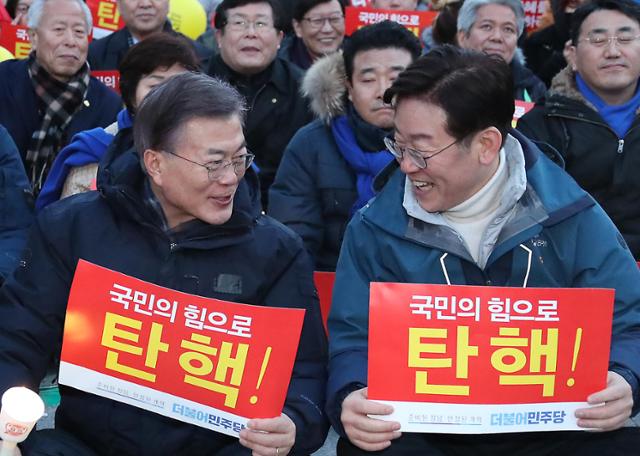 2017년 3월 당시 더불어민주당 대선주자인 문재인(왼쪽) 대표와 이재명 성남시장이 서울 광화문광장에서 열린 박근혜정권퇴진 비상국민행동 주최로 열린 '19차 범국민행동의 날' 촛불집회에서 대화를 하고 있다. 연합뉴스