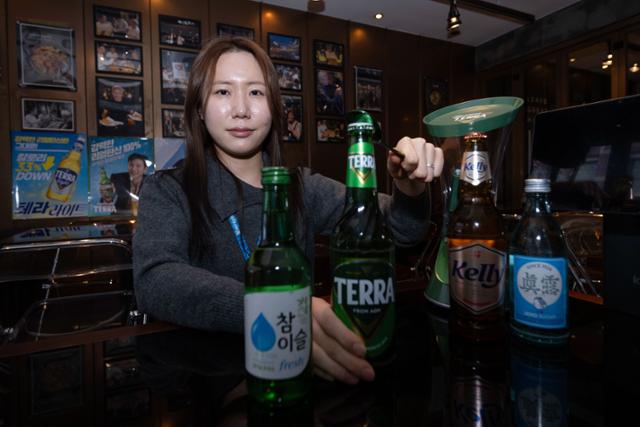 서울 강남구 깐부치킨 삼성점에서 강혜지 하이트진로 주임이 자사 제품인 참이슬, 테라, 켈리, 진로 등을 놓고 포즈를 취하고 있다. 강 주임은 지난해 10월 30일 젠슨 황 엔비디아 CEO, 이재용 삼성전자 회장, 정