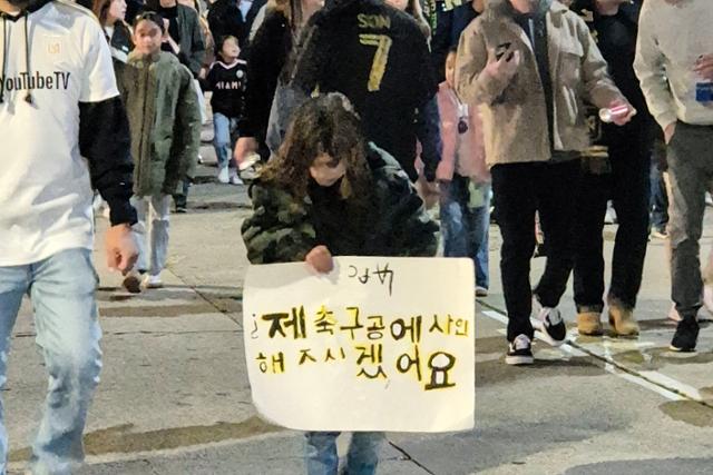LAFC-인터마이애미 개막전을 관람하기 위해 경기장을 찾은 외국인 소녀가 삐뚤삐뚤한 한글로 손흥민 선수의 사인을 요청하는 팻말을 들고 있다.