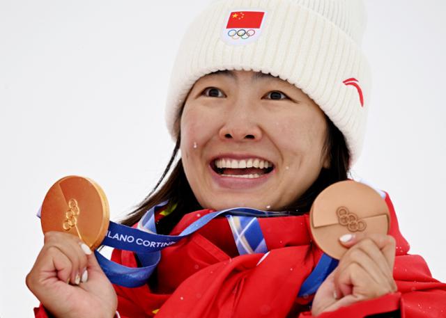 중국 쉬멍타오가 21일 이탈리아 리비뇨의 리비뇨 에어리얼 모굴 파크에서 열린 프리스타일 스키 혼성 단체 에어리얼 시상식에서 이 종목 동메달과 앞서 획득한 금메달(여자 에어리얼)을 동시에 들어 보이고 있다. 리비뇨=로