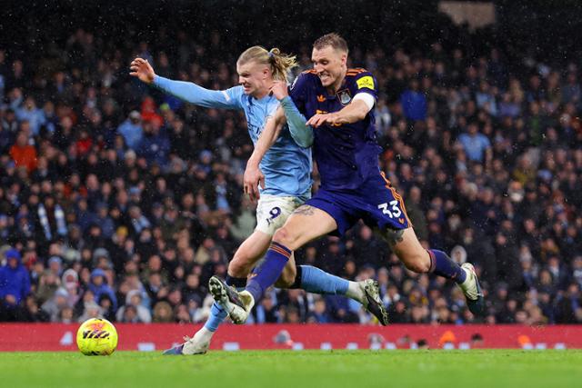 맨체스터 시티의 엘링 홀란(왼쪽)이 지난달 21일 영국 맨체스터 에티하드 스타디움에서 열린 2025~26시즌 EPL 뉴캐슬과의 경기에서 수비수 댄 번과 몸싸움을 벌이고 있다. 로이터 연합뉴스