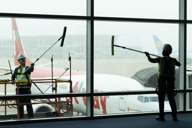 26일 인천국제공항 탑승동에서 공사 관계자들이 봄맞이 외벽 유리창 청소를 하고 있다.영종도=강예진 기자