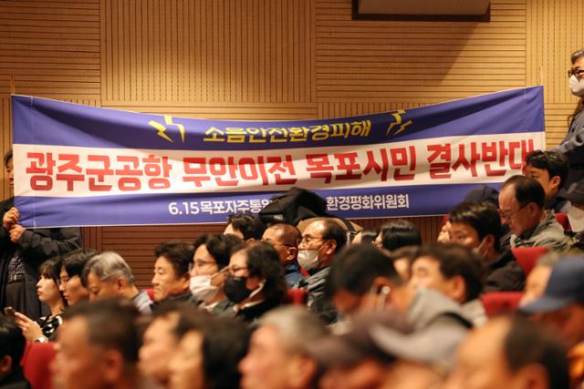 1일 전남 무안군 승달문화예술회관 대강당에서 열린 광주 군공항 주민 설명회에서 시민단체 관계자들이 군공항 이전 반대 현수막을 들고 있다.무안=연합뉴스