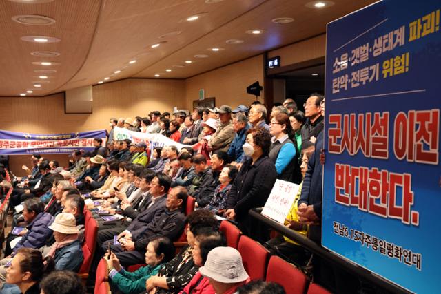 1일 전남 무안군 승달문화예술회관 대강당에서 열린 광주 군공항 주민 설명회에서 시민단체 관계자들이 군공항 이전 반대 내용이 담긴 피켓을 들고 있다.무안=연합뉴스