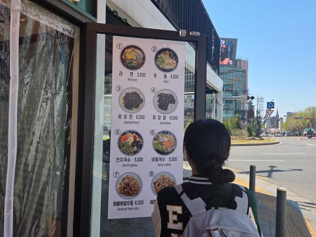 7일 오후 서울 서대문구 근처 식당 앞에서 한 대학생이 메뉴를 구경하고 있다. 나민서 기자