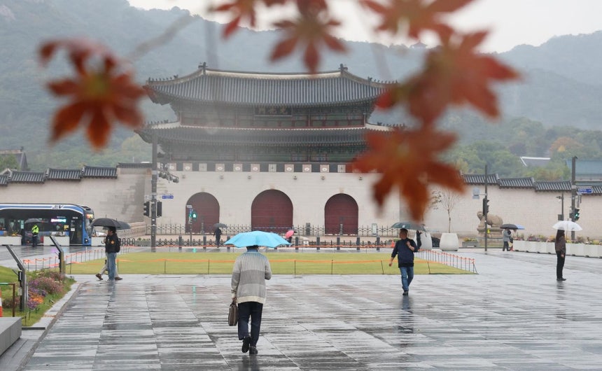 가을비가 내리는 13일 서울 종로구 광화문광장 인근에서 시민들이 우산을 쓴 채 이동하고 있다.연합뉴스
