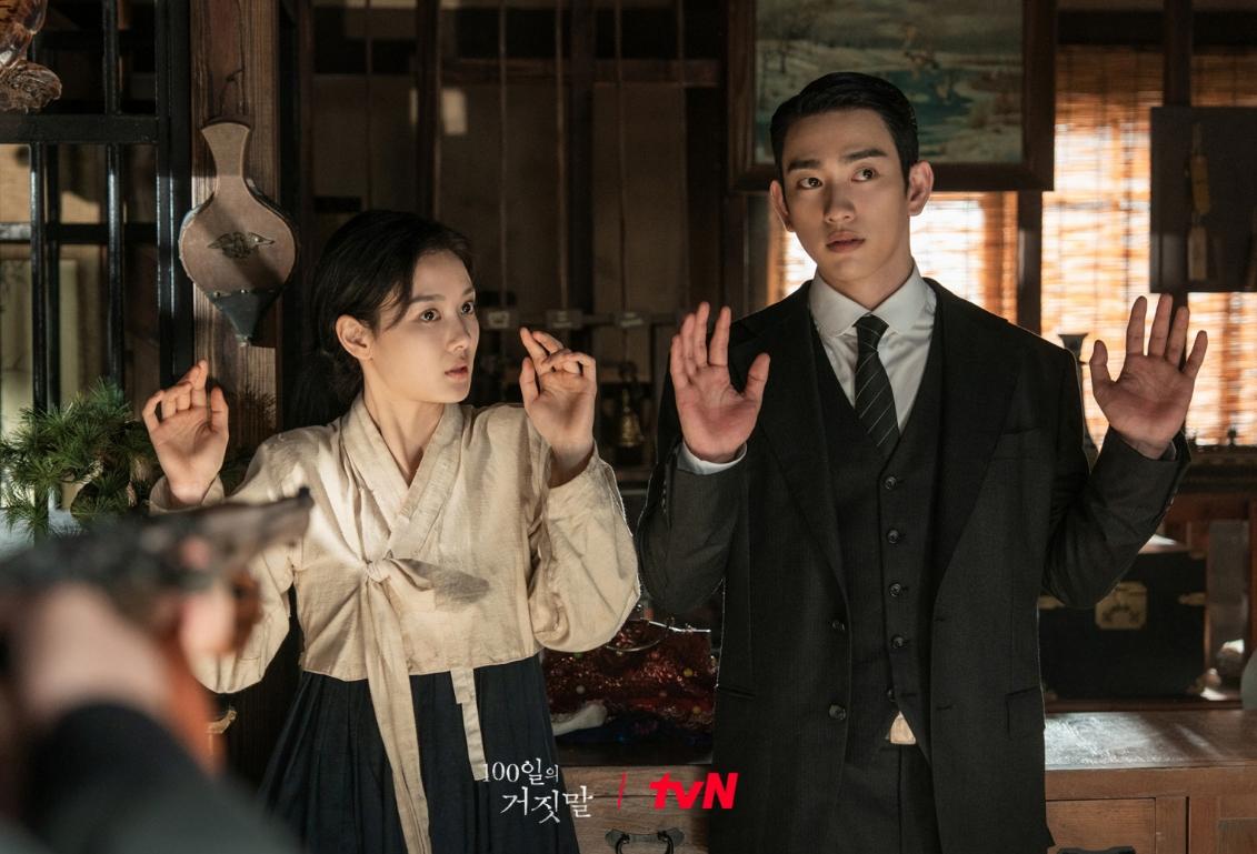 時代劇『100日の嘘』で、韓服姿のキム・ユジョンとスーツ姿のパク・ジニョンが両手を上げて向かい合う場面