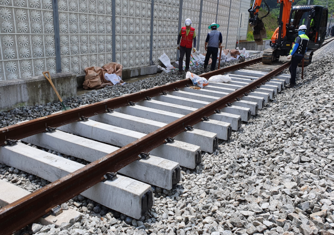 철도연이 자갈 충격을 줄이기 위해 개발한 EPDM 패드 받침목을 오송시험선에 설치하고 있다.철도연 제공