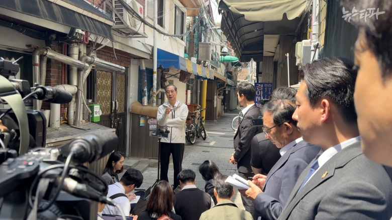 한덕수 전 국무총리가 2일 대선 출마 선언 후 첫 공개 일정으로 서울시 종로구 돈의동 쪽방촌을 방문했다.사진은 한 전 총리가 쪽방촌 골목에서 '백브리핑'을 열고 질문에 답변하는 장면이다.