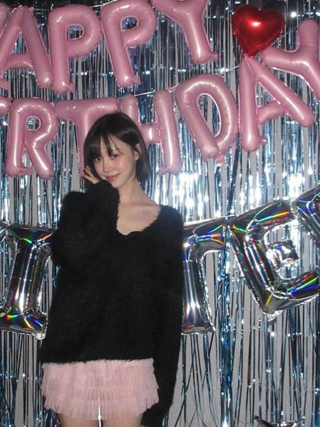 Winter in black knit and pink skirt at her birthday celebration