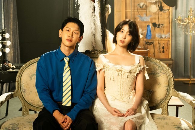 ミュージックビデオのセットでソファに並んで座るCrushとIU