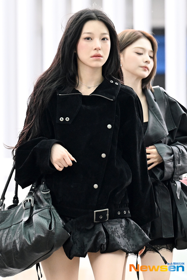 黒いコート姿のペク・ジホンを前に、仁川空港を歩くfromis_9のメンバー