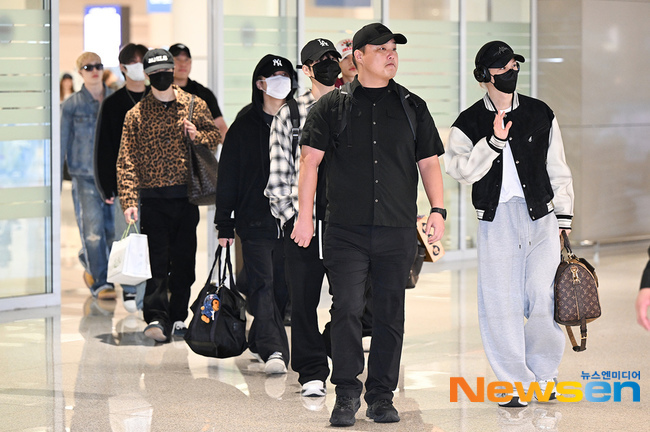 海外日程を終えて仁川国際空港に到着し、空港内を歩くStray Kidsのメンバー。帽子やマスク、カジュアルな旅行着を身につけている。