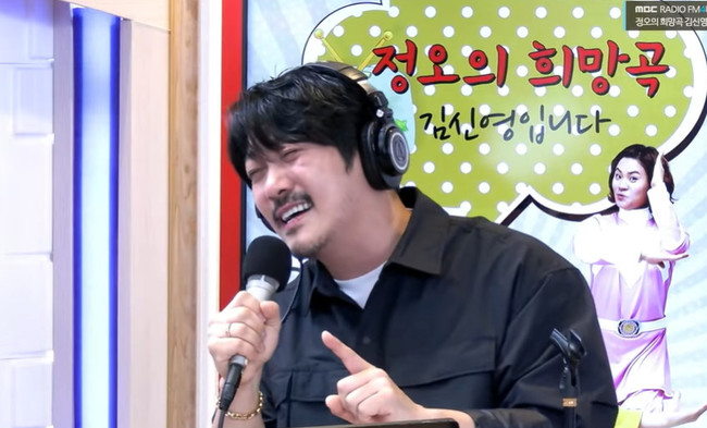 MBC FM4U『正午の希望曲キム・シニョンです』のスタジオで、ヘッドホンを着けてマイクに向かうKCM