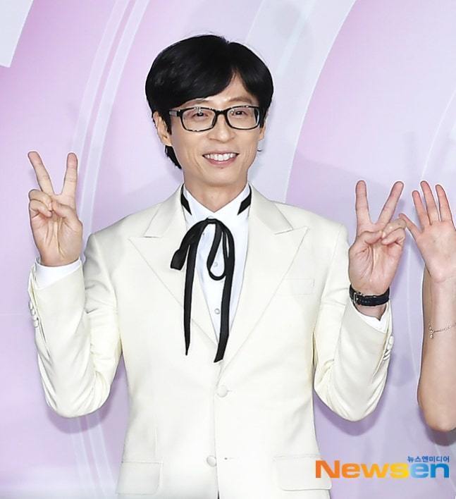 白いスーツ姿でピースサインをするユ・ジェソク