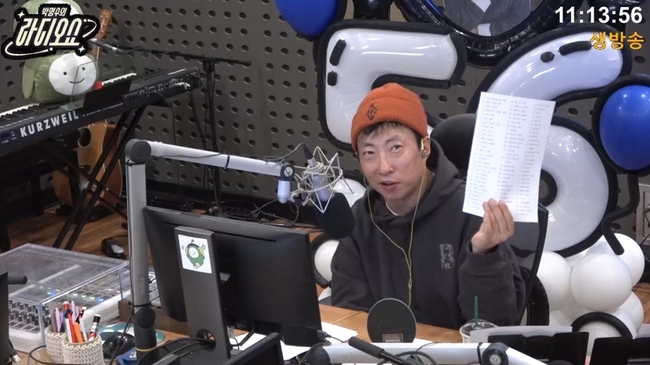 KBS Cool FM「パク・ミョンスのラジオショー」の生放送で、オレンジ色のニット帽をかぶりリスナーの相談に答えるパク・ミョンス。