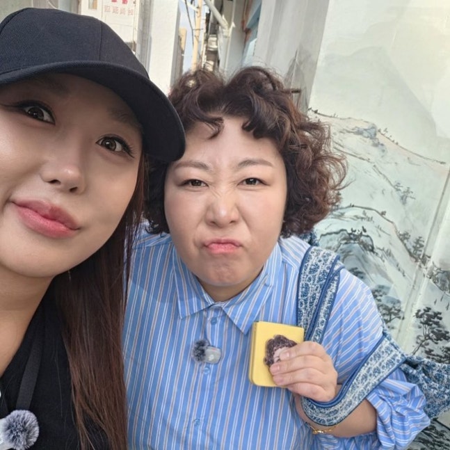 帽子をかぶったプンジャがシン・ギルと並ぶ自撮り写真